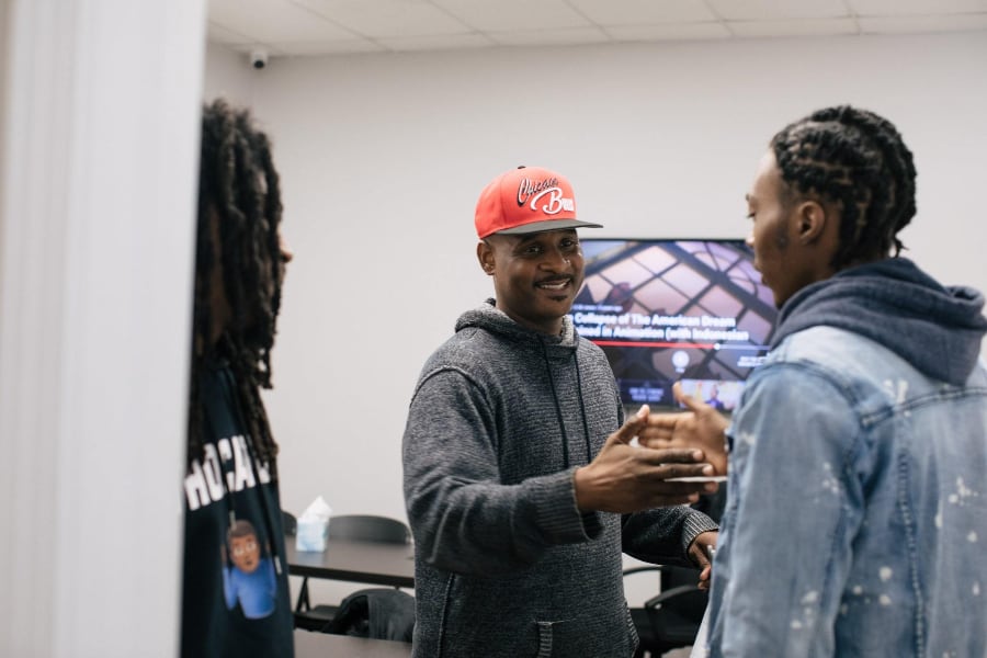 men shaking hands at inner-city muslim action network office