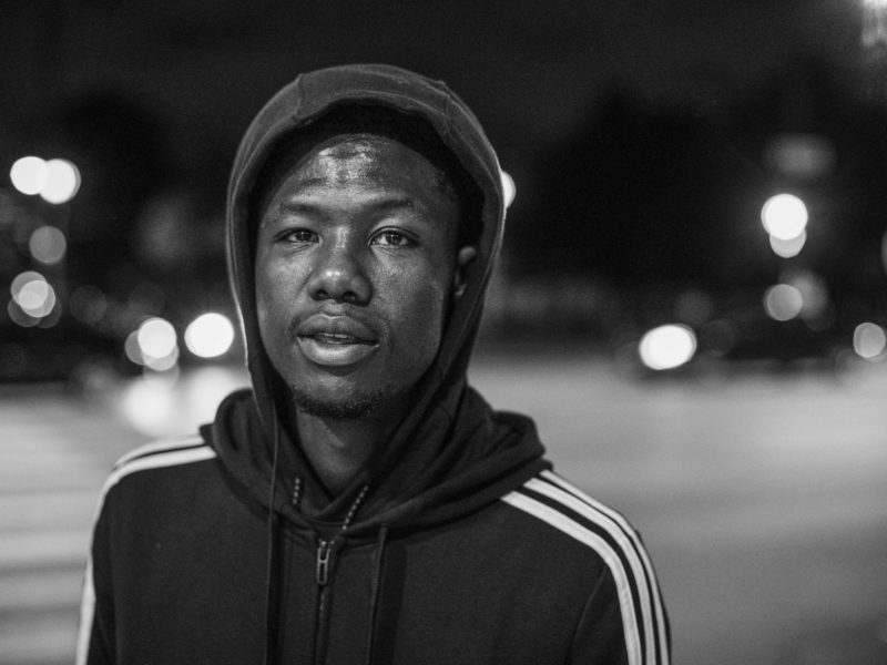 man wearing hoodie outside at night